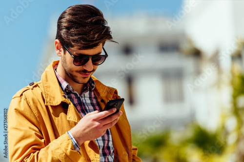 Fashionable businessman using mobile outdoors