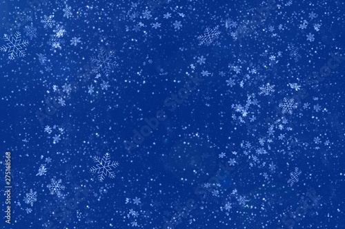 Blue abstract background with white snowflakes. Copy space. New year and Christmas celebration concept.