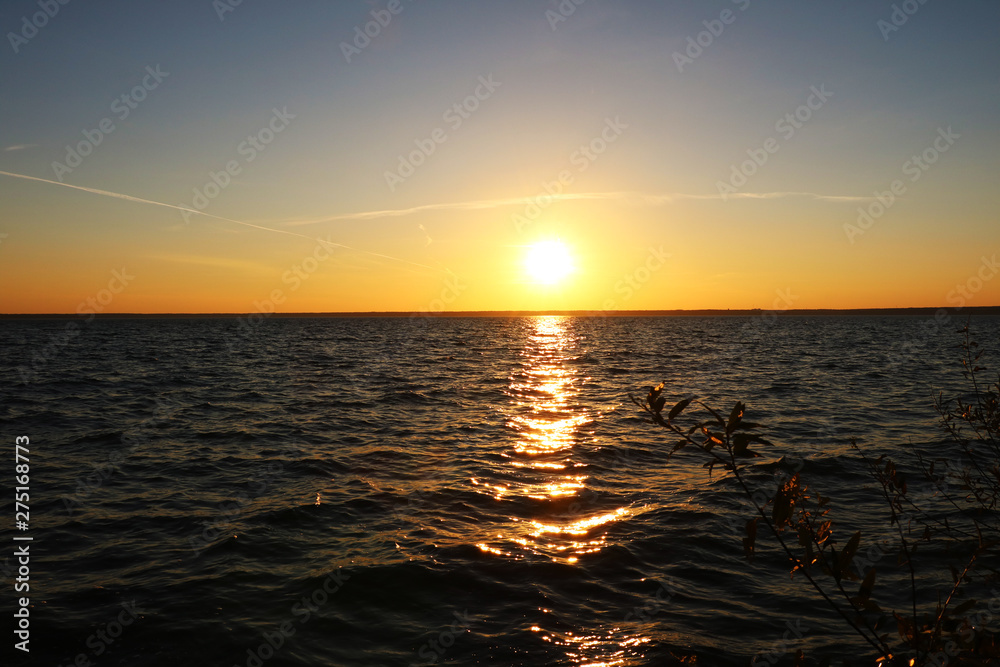 Beautiful sunset on the shore of a blue calm lake