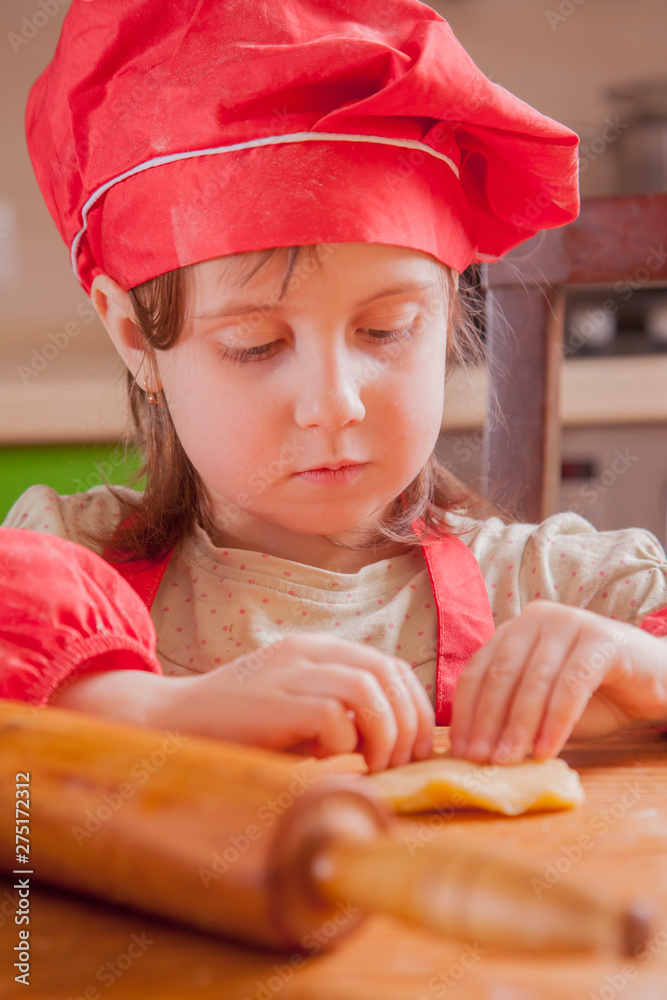Little cute child girl chef preparing the dough for bake cookie . Food, сooking process, sweets concept. Little cute child girl chef preparing the dough for bake cookie . Food, сooking process, sweets concept.