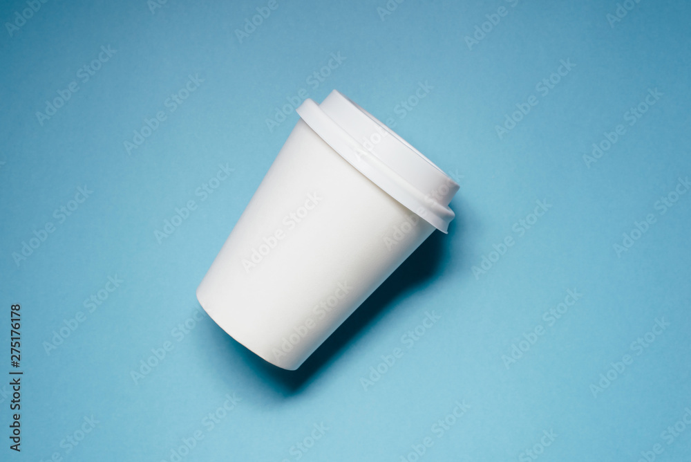 One paper cups for coffee or tea on blue background. One paper cups for coffee or tea on blue background.