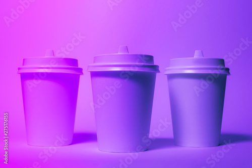 Paper disposable cups in trendy neon light. photo