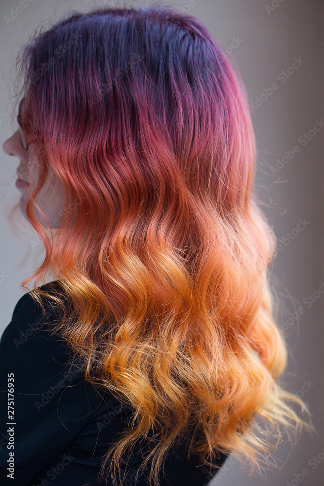 Naklejka premium Woman with bright color gradient dyed long curly hair