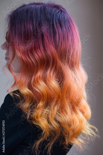 Woman with bright color gradient dyed long curly hair