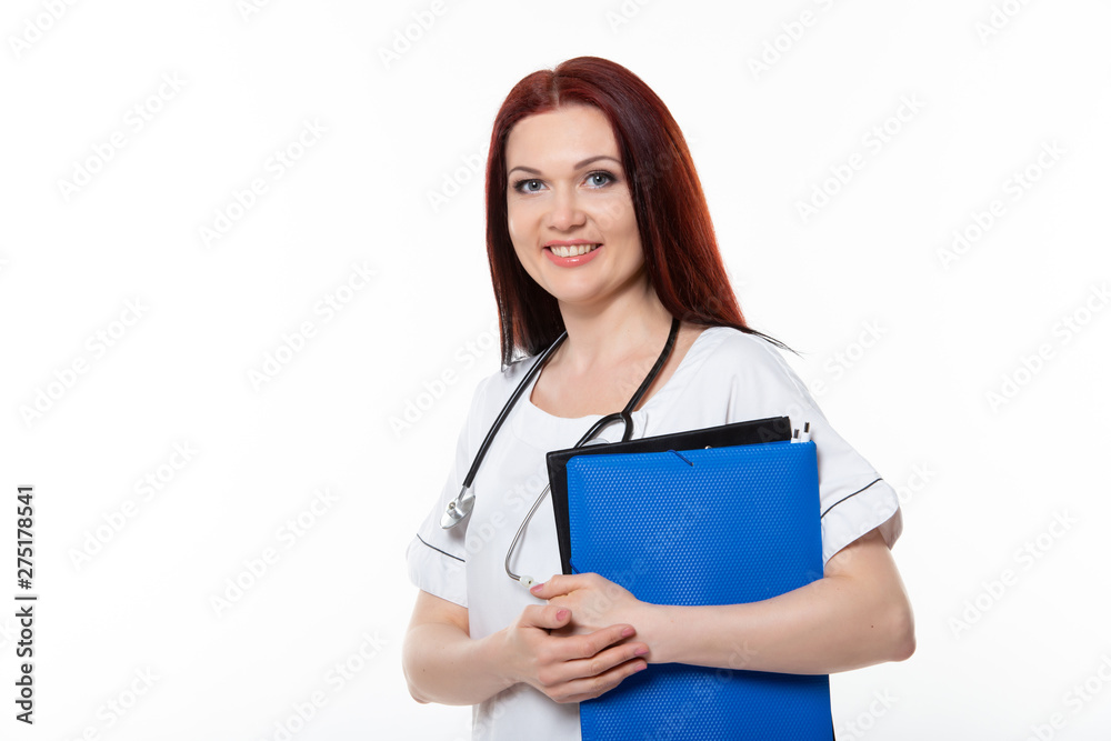 Happy young female family doctor holds blue folder with documents, has friendly expression, isolated white background. Medicine concept. Happy young female family doctor holds blue folder with documents, has friendly expression, isolated white background. Medicine concept.