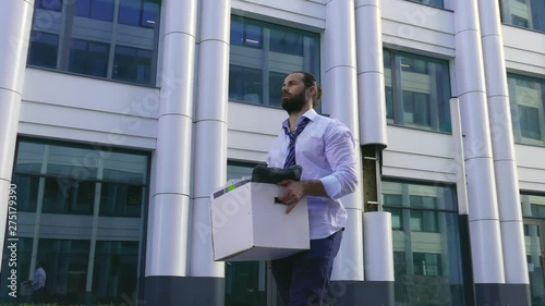 Wallpaper Mural A dismissed handsome man with a beard, a manager in formal attire, upset after being fired, goes along with a box of personal belongings. Close-up, depression, bad mood, bad day. Torontodigital.ca