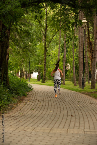 Wallpaper Mural  A beautiful fitness girl runs in the park. Nature and healthy life Torontodigital.ca