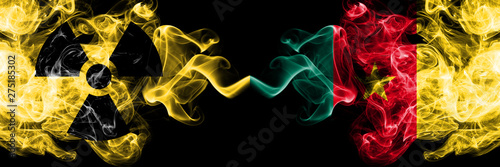 Cameroon, Cameroonian vs nuclear smoky mystic flags placed side by side. Thick colored silky smokes combination of Cameroon, Cameroonian flag and radioactive sign. © Vlad