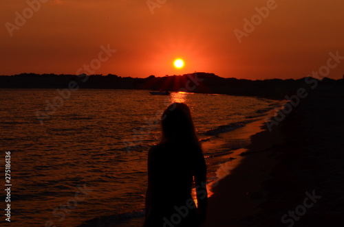 Silhouette mof women on beach against sky during sunset