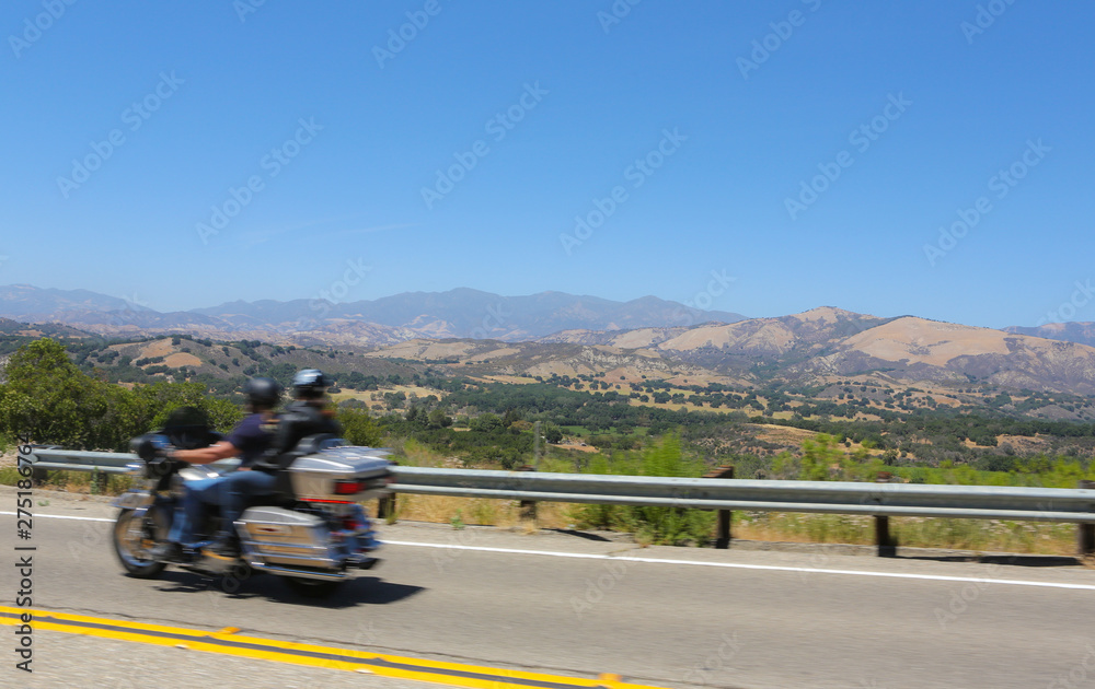 Couple on a motorcycle driving along the highway in California. 