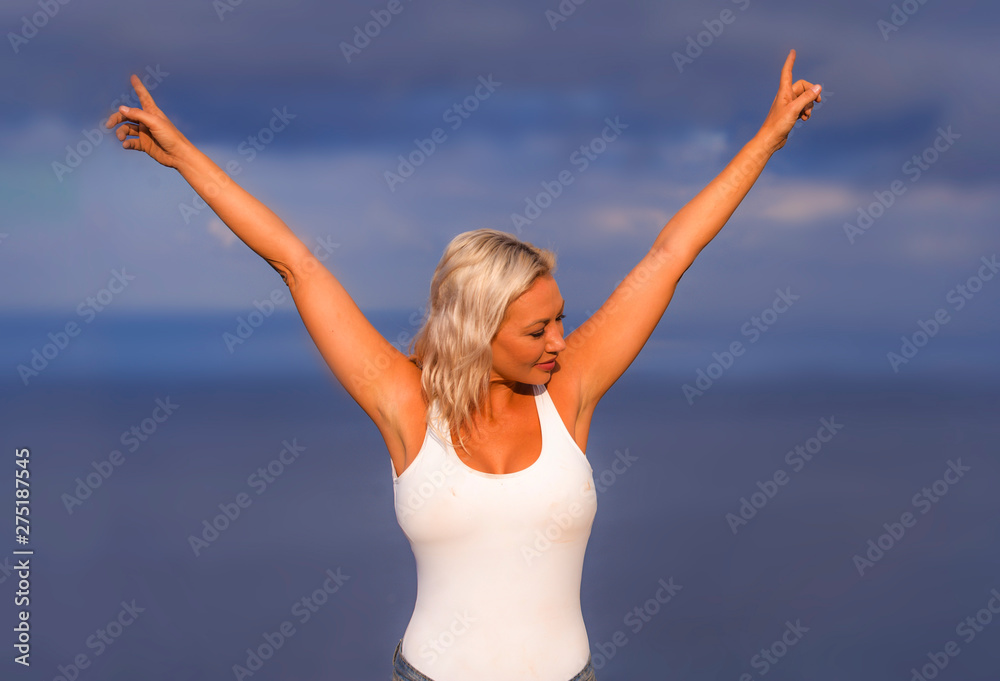 young attractive and beautiful 30s blond hair woman in casual top and denim shorts spreading arms happy and cheerful posing isolated on sea blue and sky young attractive and beautiful 30s blond hair woman in casual top and denim shorts spreading arms happy and cheerful posing isolated on sea blue and sky