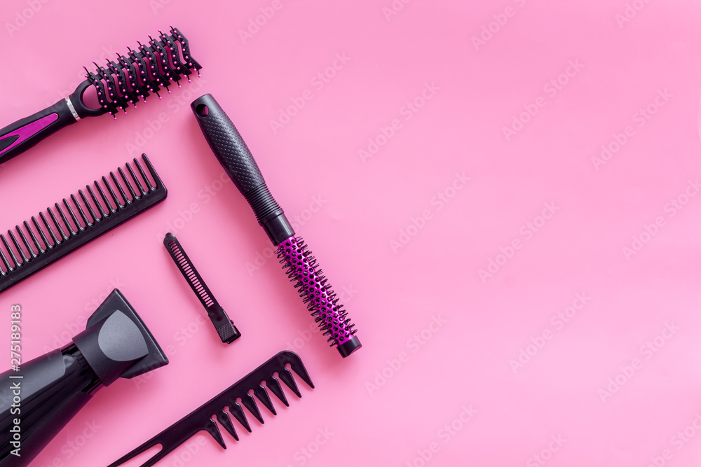 Combs, dryer and hairdresser tools in beauty salon work desk on pink background top view mockup
