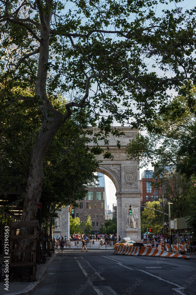 New York, NY / USA - May/27/2019: People walk on a sunny summer day at Washington Square Park.