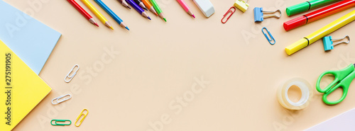 School supplies stationery, colour pencils, paints, paper on pastel orange background, back to school concept with free copy space for text, modern elementary education. Kids desk, top view, mockup.