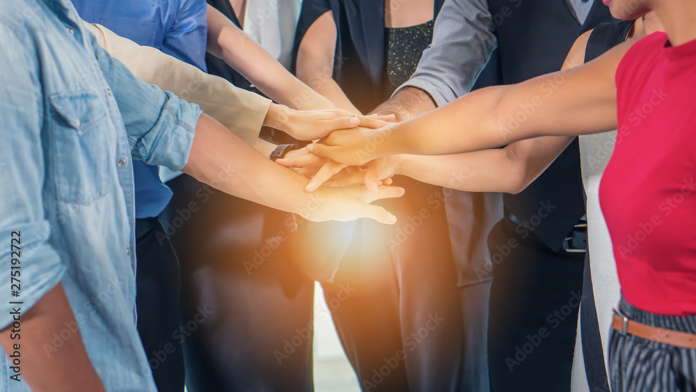 business people stacking hands together to cheer up team spirit