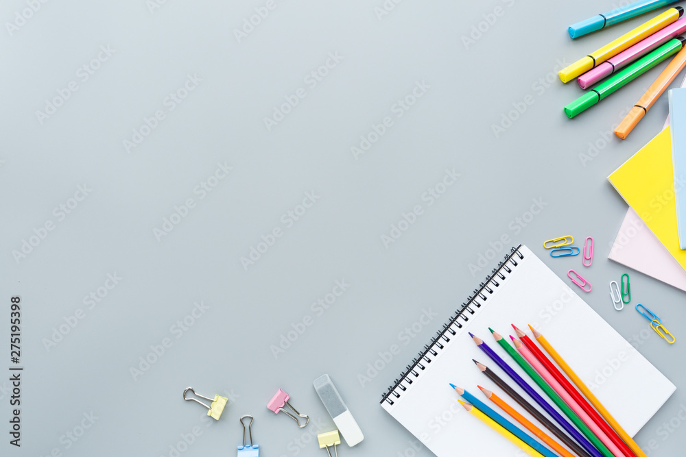 Fototapeta premium School supplies stationery, colour pencils, clips, paper on gray background, back to school concept with copy space for text, overhead, modern elementary education. flat lay, top view, mockup