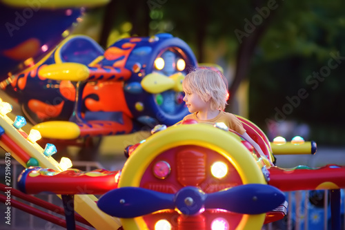 Fotografie Little boy having fun on attraction in public park