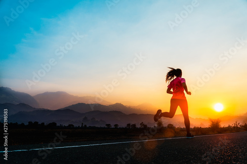 Fototapeta Naklejka Na Ścianę i Meble -  Young woman enjoys running outside with beautiful summer evening in the countryside.