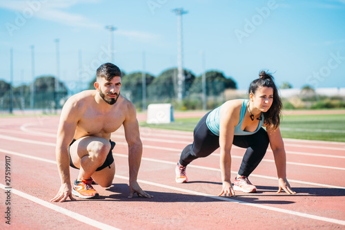 man and woman running together in the sports track