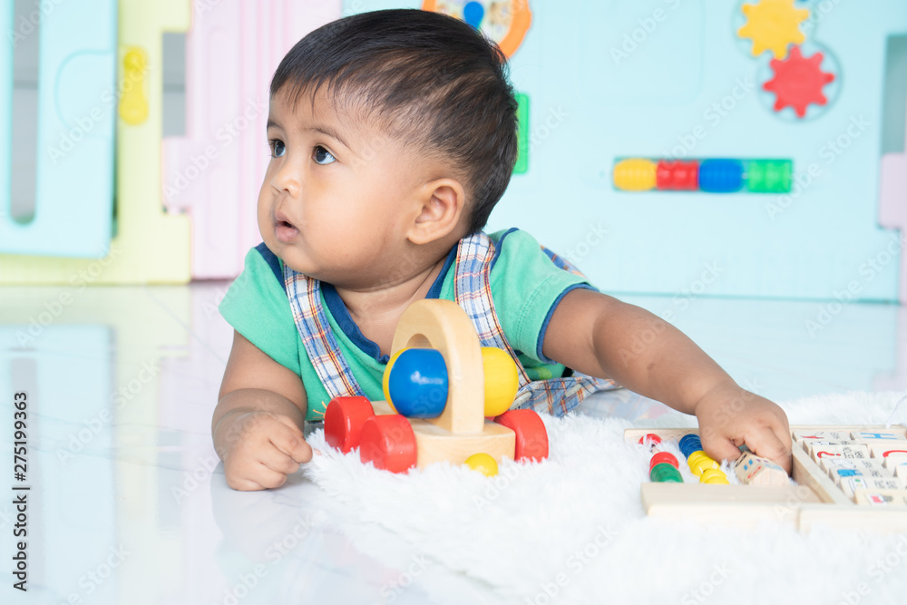 ittle baby boy lying and play wooden toy ittle baby boy lying and play wooden toy