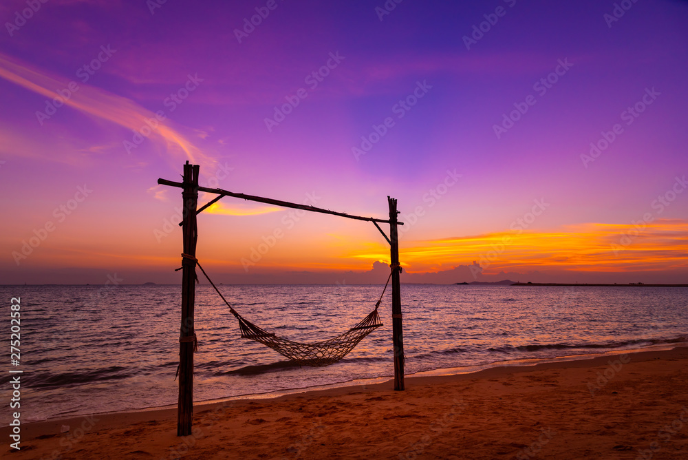 A hammock on beach for holiday relaxing with beautiful twilight sky back ground at sunset time.