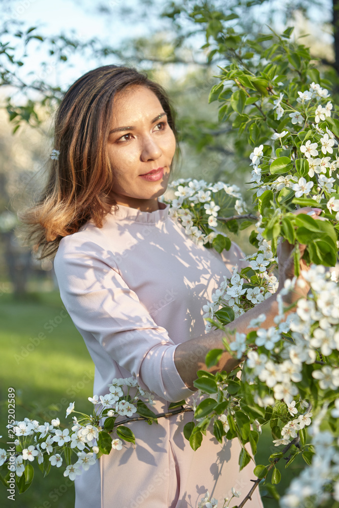 girl with flowers. gorgeous model in the spring garden. the girl near the tree in the spring. the concept of spring.