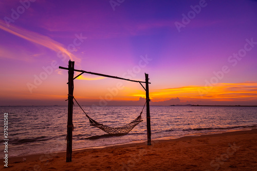 A hammock on beach for holiday relaxing with beautiful twilight sky back ground at sunset time.