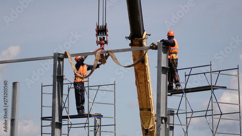 Construction of the shop of metal .Workers and equipment on the construction site.