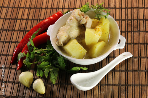 ready chicken and potatoes in a porcelain bowl. spicy seasonings to meat. photo