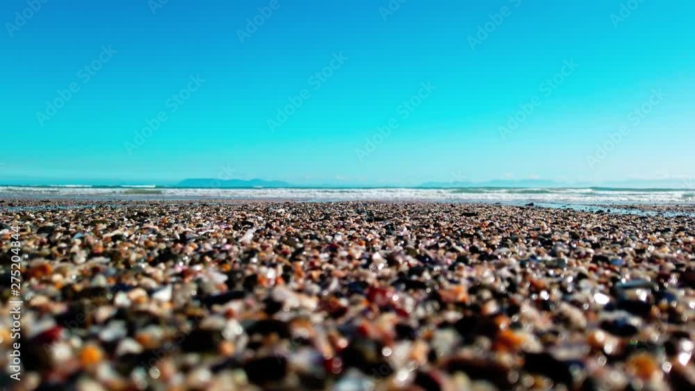 Close Up: Turquoise ocean waves roll in on the peaceful shore with sea birds in the background. View of swell reaching sandy beach. Close Up: Turquoise ocean waves roll in on the peaceful shore with sea birds in the background. View of swell reaching sandy beach.