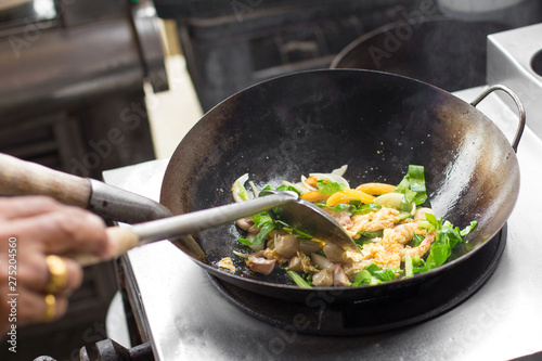 Man hand is cooking Asian style in a pan