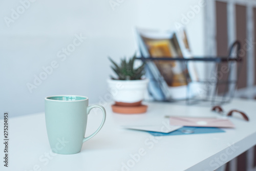 White desk table with copy space, supplies and coffee mug. Front view workspace and copy space