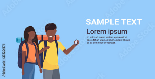 couple tourists hikers with backpacks using compass searching direction hiking concept man woman african american travelers on hike portrait horizontal copy pace flat