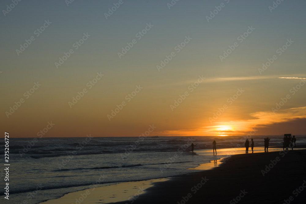 Silhouette big crowd of people having fun at sunset beach