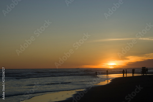 Silhouette big crowd of people having fun at sunset beach