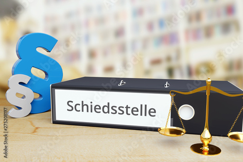 Schiedsstelle – Recht/Gesetz. Ordner auf Schreibtisch mit Beschriftung neben Paragraf und Waage. Anwalt