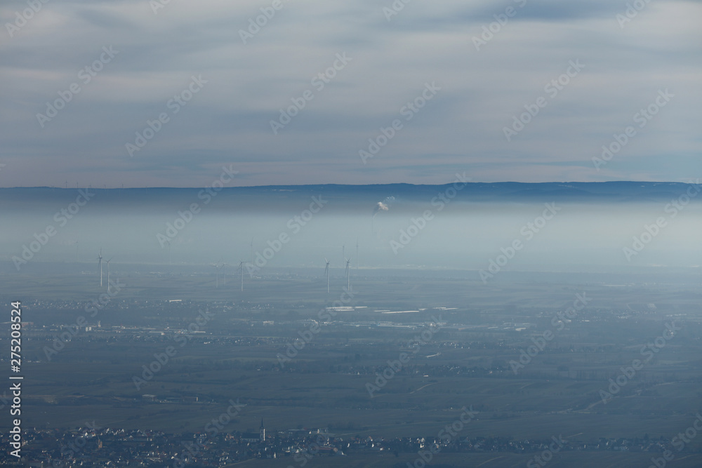 Windräder unter einer Nebeldecke und Wolkendecke