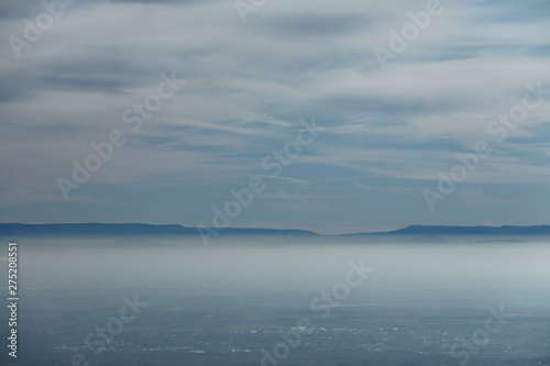 Fototapeta Naklejka Na Ścianę i Meble -  Windräder unter einer Nebeldecke und Wolkendecke