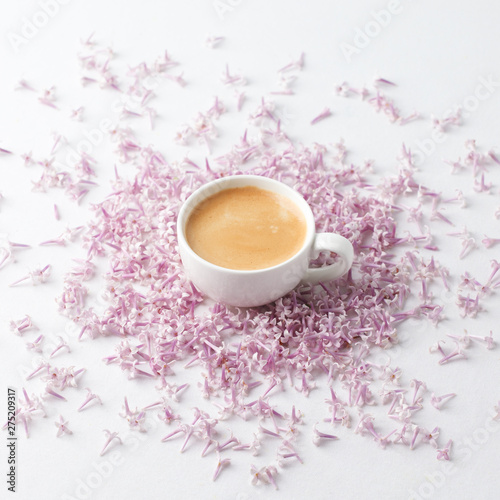 Morning breakfast with coffee cup and lilac flowers on white background. Flat lay, top view women background. Minimal concept, wedding, valentine day