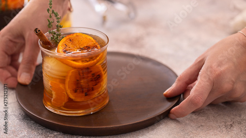 Hand holding  wooden try  with glass of Whiskey sour cocktail. Alcohol drink background.