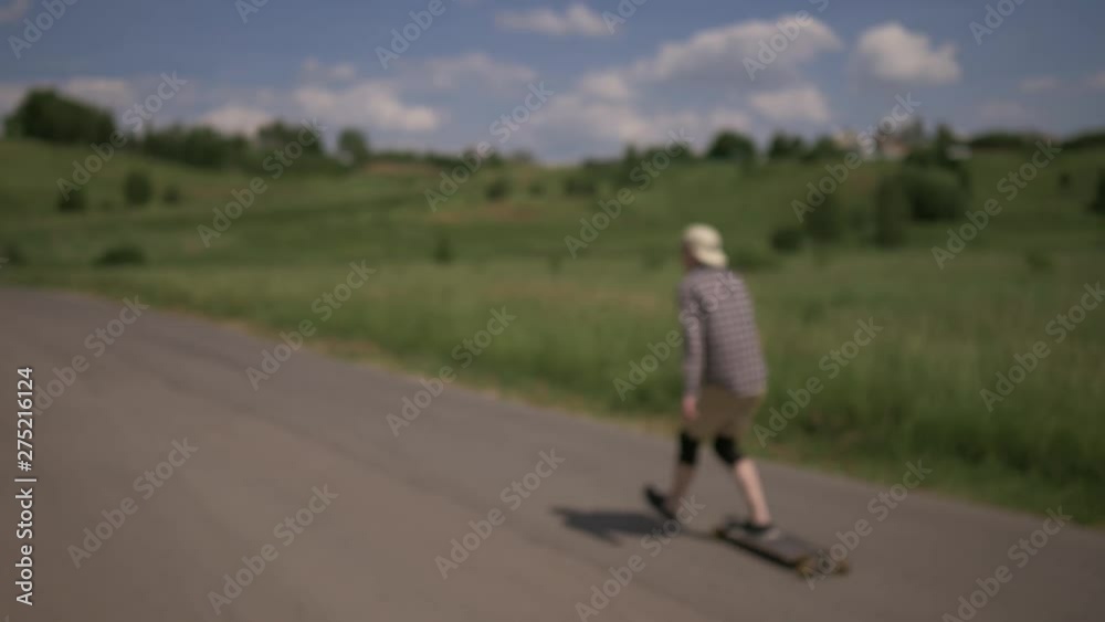 A man passes in the frame on the road on the longboard. Extreme longboard riding. Eternally young. No focus A man passes in the frame on the road on the longboard. Extreme longboard riding. Eternally young. No focus