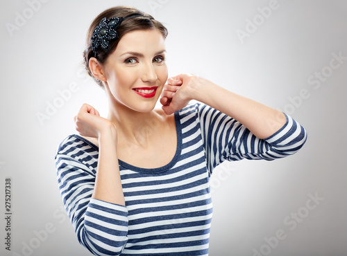 Happy girl in casual dress standing with hands raised up.