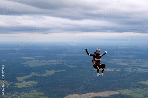 Skydiving. The alone girl is in the sky.