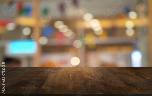 Empty dark wooden table in front of abstract blurred bokeh background of restaurant . can be used for display or montage your products.Mock up for space.