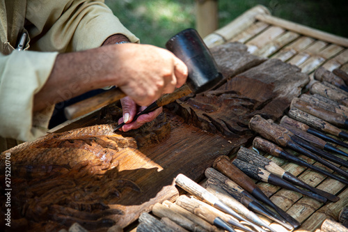 Closeup hands of local craftman carve with gouge tool and create an amazing Thai Northern handcraft art in Thailand