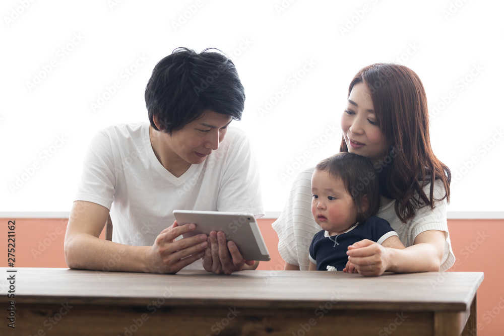 子供にタブレットを見せる両親 子供にタブレットを見せる両親
