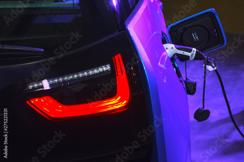 EV Car or Electric car at charging station with the power cable supply plugged. Eco-friendly alternative energy concept