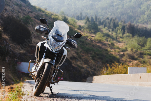 Motorcycle parked on side of a mountain road photo