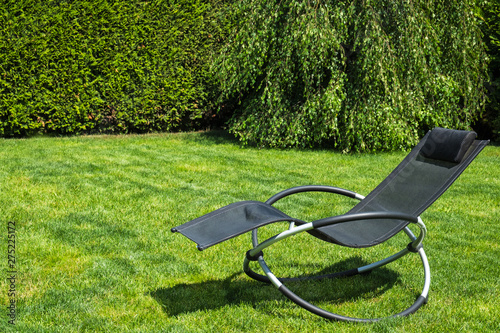 Rocking lounger on a green grass. Summer time. Copy space