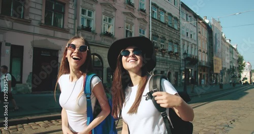 Two beautiful ladies enjoying sightseeing in ancient european city on pleasant summer day